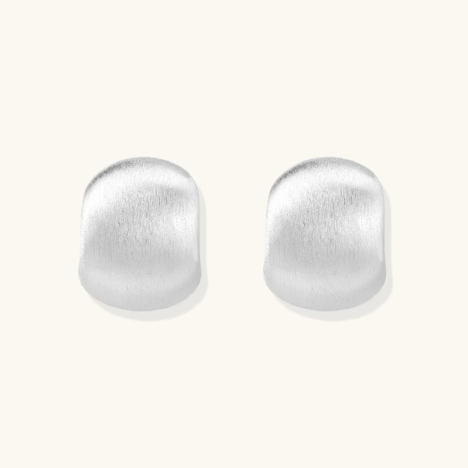 Brushed sterling silver cushion-shaped stud earrings with matte finish on white background